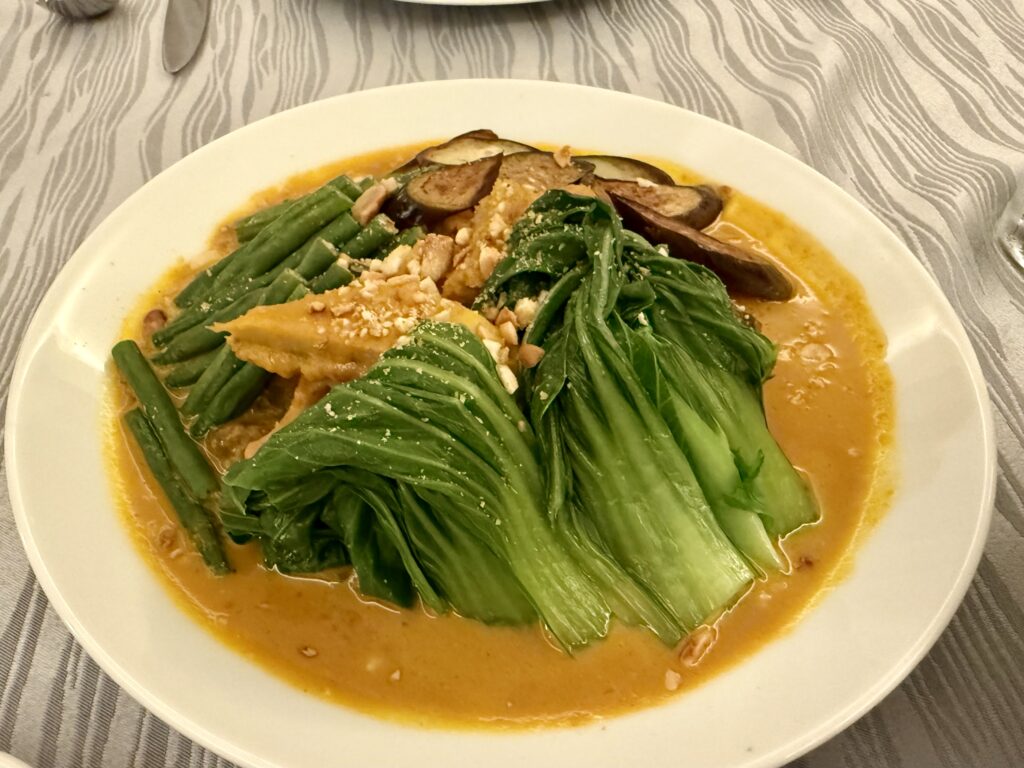 ココナッツカレーみたいな色のソースに、青梗菜やいんげん、肉、なす